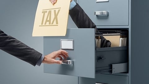 Tax refund folder pulled from a filing cabinet, symbolizing debt repayment and financial planning