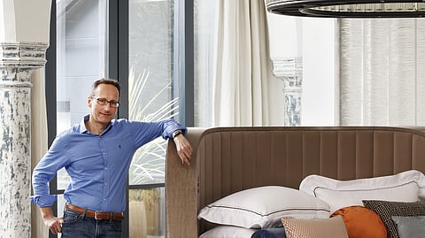 Savoir CEO Alistair Hughes Poses Beside a Custom-Designed Statement Bed