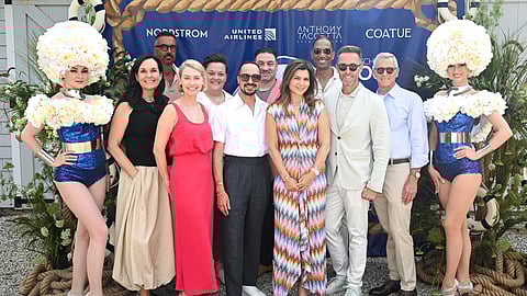 Group of guests pose with flower-costumed performers at HMI benefit