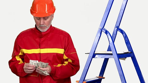 Contractor counting cash beside a blue ladder