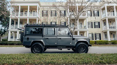 Gray Custom Defender 110 parked in front of cream-colored townhomes