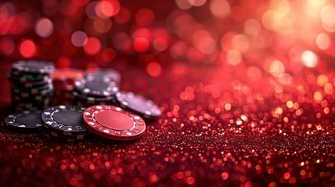 Red casino poker chips stacked on a glittering red background