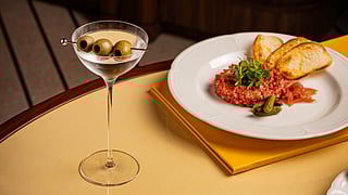 Cocktail with olives and dishes on a table in the Miami Design District