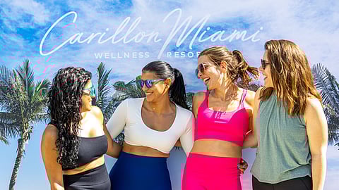 Four women smiling together at Carillon Miami Wellness Resort backdrop
