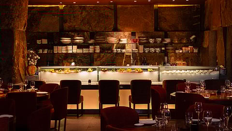 Zuma New York sushi counter with fresh seafood and stone wall backdrop