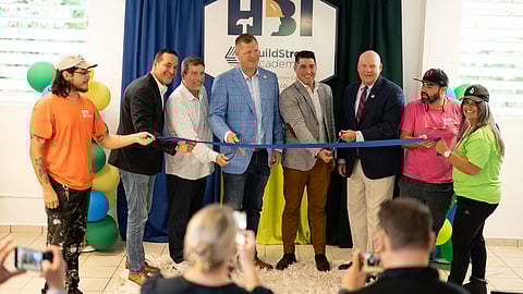 BuildStrong Academy logo backdrop with leaders at Puerto Rico opening event