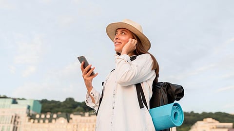 Traveler with phone and backpack, symbolizing AI-powered travel apps