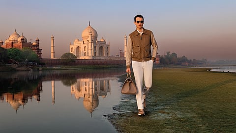 Man walking with Stefano Ricci bag at sunrise near Taj Mahal