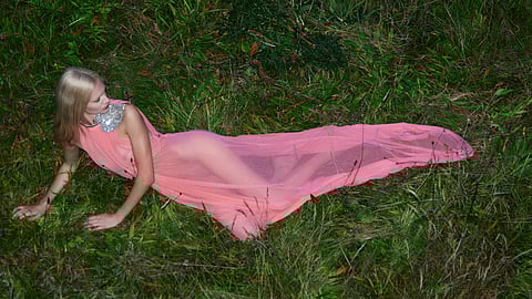 Model reclines in a sheer peach gown by David Koma