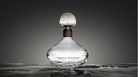 A sculptural Tequila Purísima bottle emerges from water