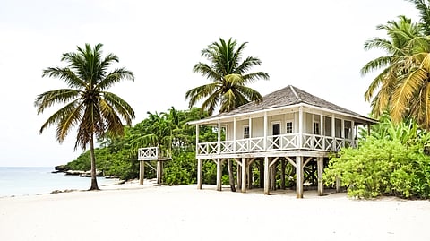 Beachfront villa surrounded by palm trees on a Caribbean island