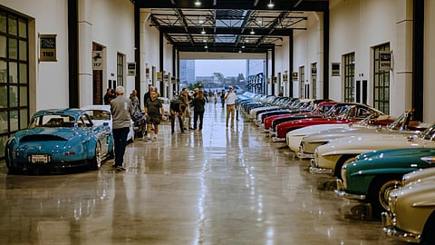 Guests viewing classic cars inside Costa Mesa’s Finish Line Auto Club