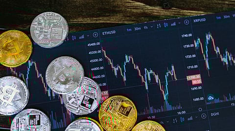 Gold and silver cryptocurrency coins placed on a financial trading chart