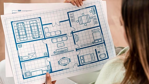 Person reviewing home blueprints with room layout design