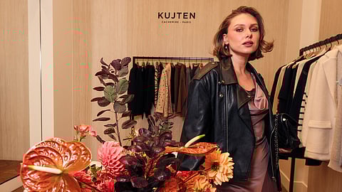Woman in satin dress and leather jacket at KUJTEN Madison Avenue boutique