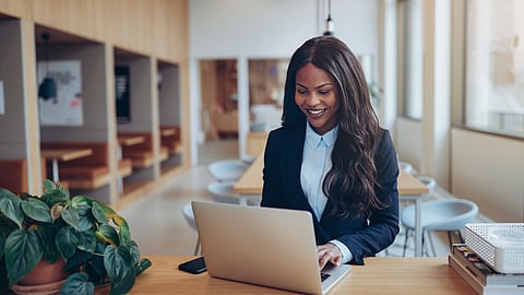 Professional woman smiling while working on laptop