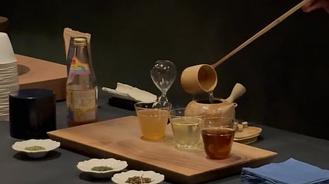 Tea ceremony setup with cups, wooden tray, and herbal blends at Sōrate