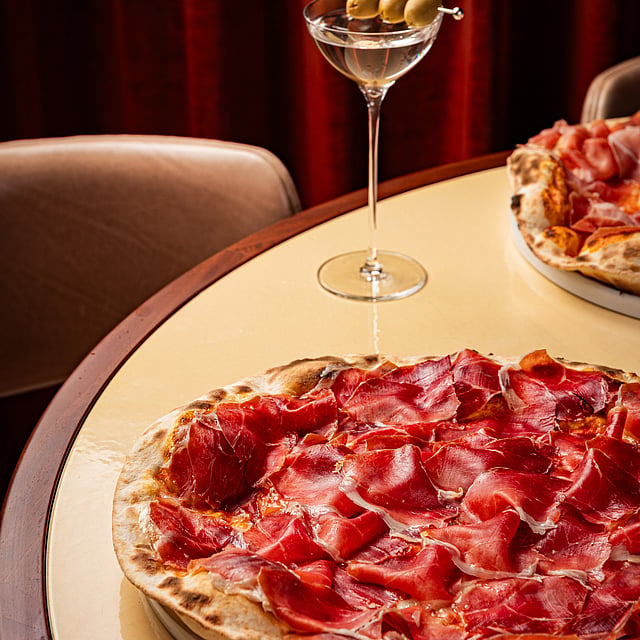 Prosciutto pizza and classic martini