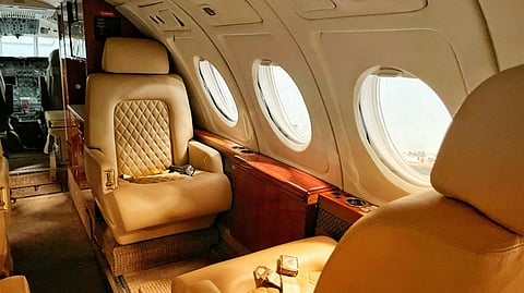 Interior of a private jet with leather seating and round windows