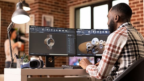 3D designer working on product models using dual monitors in a studio