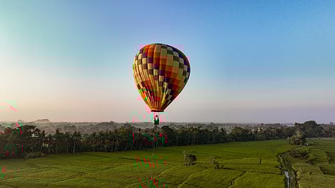 Hot air balloon over lush rice fields at sunrise in Bali