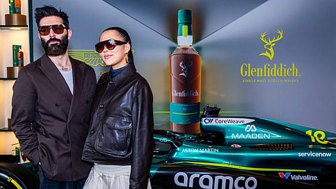 Guests pose by the Aston Martin F1 car at the Glenfiddich event