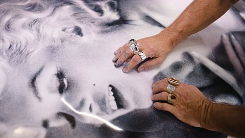 Hands with rings working atop a Marilyn Monroe art print
