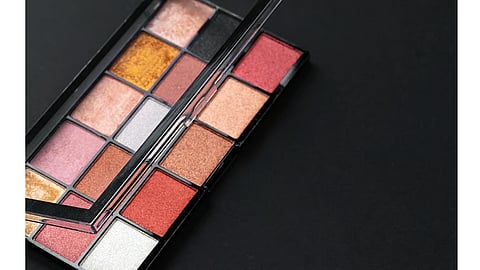 A close-up of an eyeshadow palette with warm shimmer shades