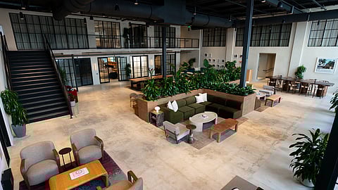 Open atrium with lounge seating and greenery at Knotel at Wyncatcher workspace