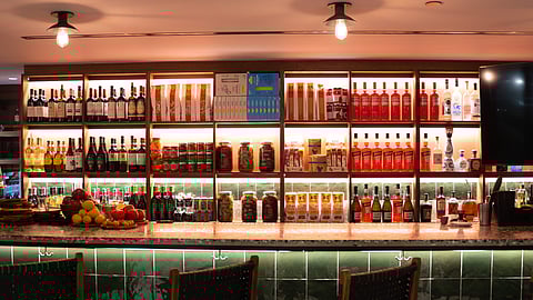 Backlit shelves of Italian wines and aperitivi behind the bar at Al Bàcaro