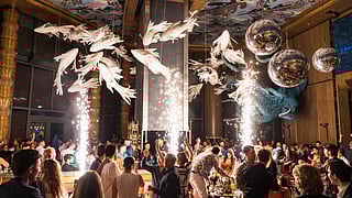 Guests celebrate New Year’s Eve with sparklers and disco balls inside a Miami restaurant