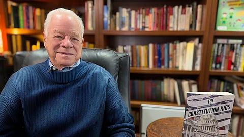 Author Gary Gabel seated beside his book The Constitution Kids on constitutional history