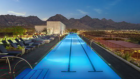 Rooftop lap pool with lounge seating and mountain views at Optima McDowell Mountain in Scottsdale