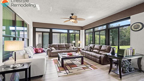 Spacious Florida room with leather sofas, floor-to-ceiling windows, and garden views