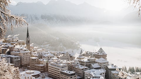 Snow-covered St. Moritz village with alpine mountains and frozen lake in winter