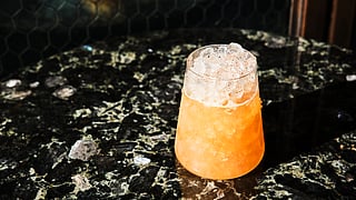 Non-alcoholic cocktail with crushed ice served in a short glass on a dark marble table