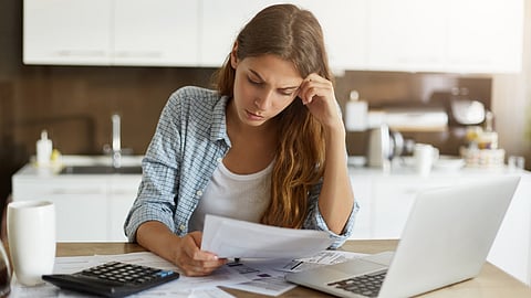 Woman reviewing financial documents and laptop while planning a career break