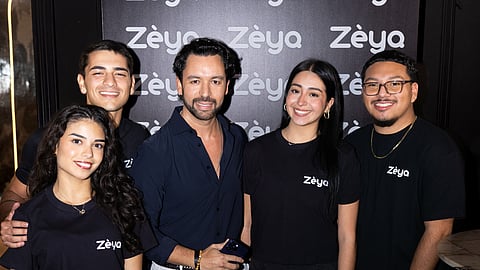 Zèya founder stands with team members in front of a branded Zèya backdrop at a launch event