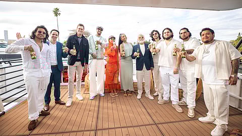 Group of celebrities posing on a yacht at the Dos Equis Sailgate celebration in Miami