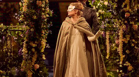 Léonore Baulac and Guillaume Diop in costume beneath a floral Bridgerton arch in Paris