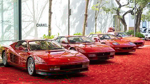 Red Ferrari supercars displayed on a red carpet outside Chanel in Miami