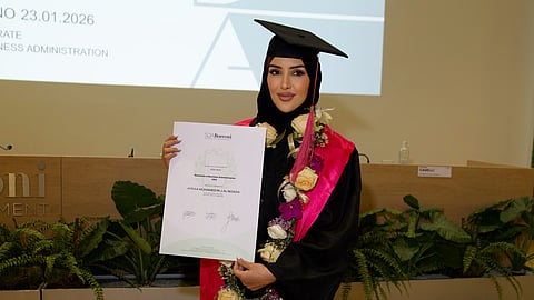 Afraa Al-Noaimi holding her DBA diploma at SDA Bocconi School of Management graduation ceremony