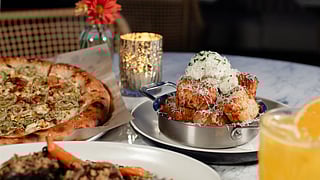 A spread of North Italia dishes, including pizza and cheesy appetizers, served on a restaurant table