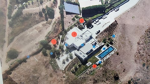 Aerial view of one intact home beside wildfire-destroyed neighboring properties
