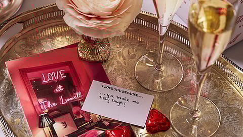 Champagne flutes, handwritten love notes, and chocolates arranged on a silver tray at The Lowell