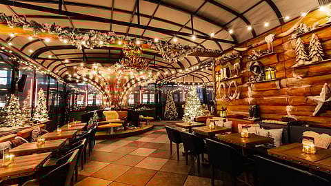 Interior of Magic Hour Mountain Lodge with alpine décor, candlelit tables, and winter chalet design