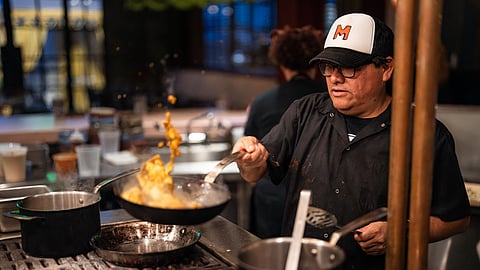 Chef Poncho Martinez sautés ingredients in a pan over open flame at Lugya’h LA kitchen