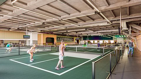 Wide view of indoor pickleball courts with players competing at CityPickle Times Square