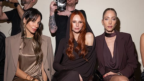 Three women seated in tonal brown and plum looks at Elisabetta Franchi FW26, Milan Fashion Week