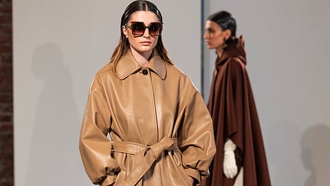 Model in camel leather coat and oversized sunglasses from AFRAA FW26 runway collection